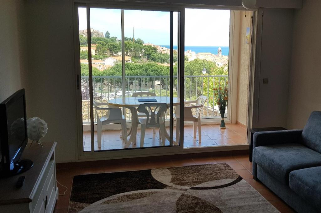 - un salon avec une table et une vue sur l'océan dans l'établissement 3AMB31 - Studio pour 3 personnes avec magnifique vue sur la baie, à Collioure