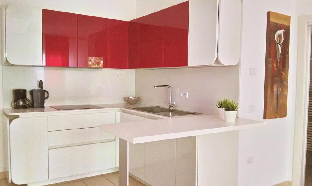una cocina blanca con armarios rojos y fregadero en Ca' Dell' Ora, en Nago-Torbole