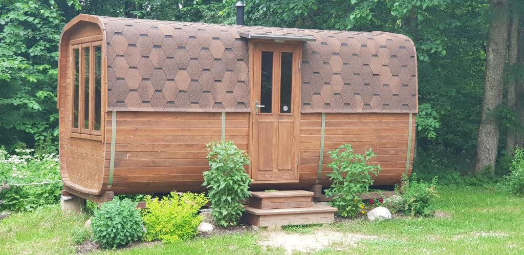 una casa de madera con dos plantas en un patio en Camping Jaunzāģeri, en Inciems