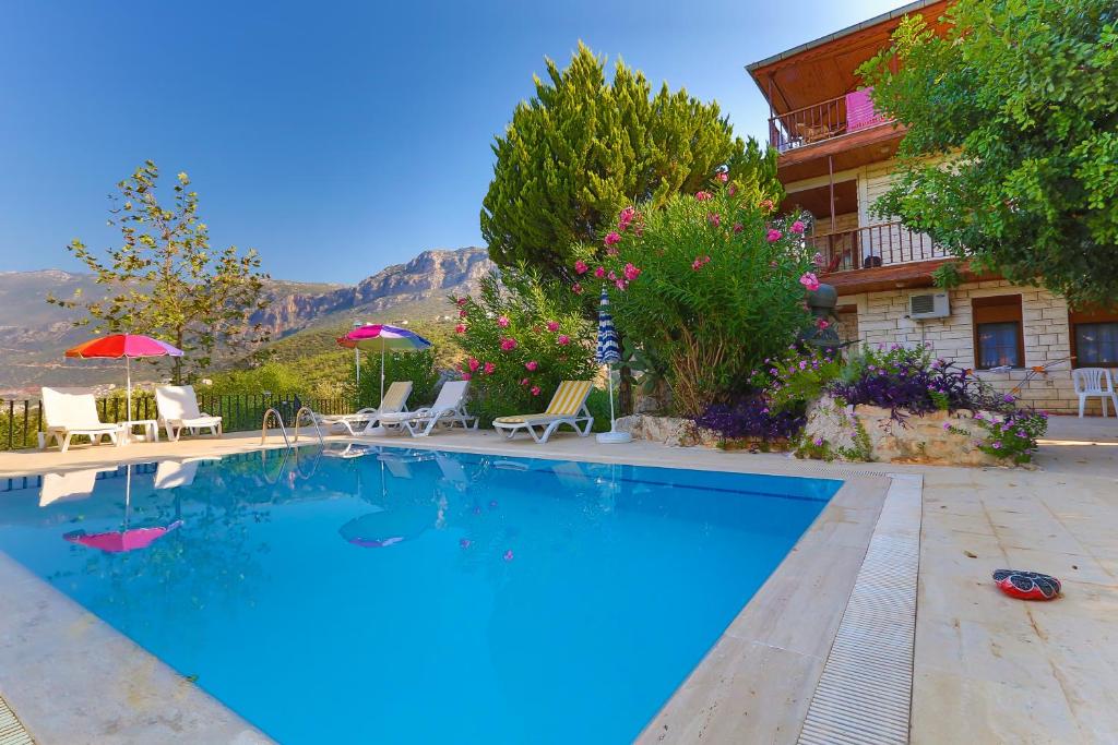 a swimming pool in front of a house at Villa Dundar - Kas Apartments in Kas