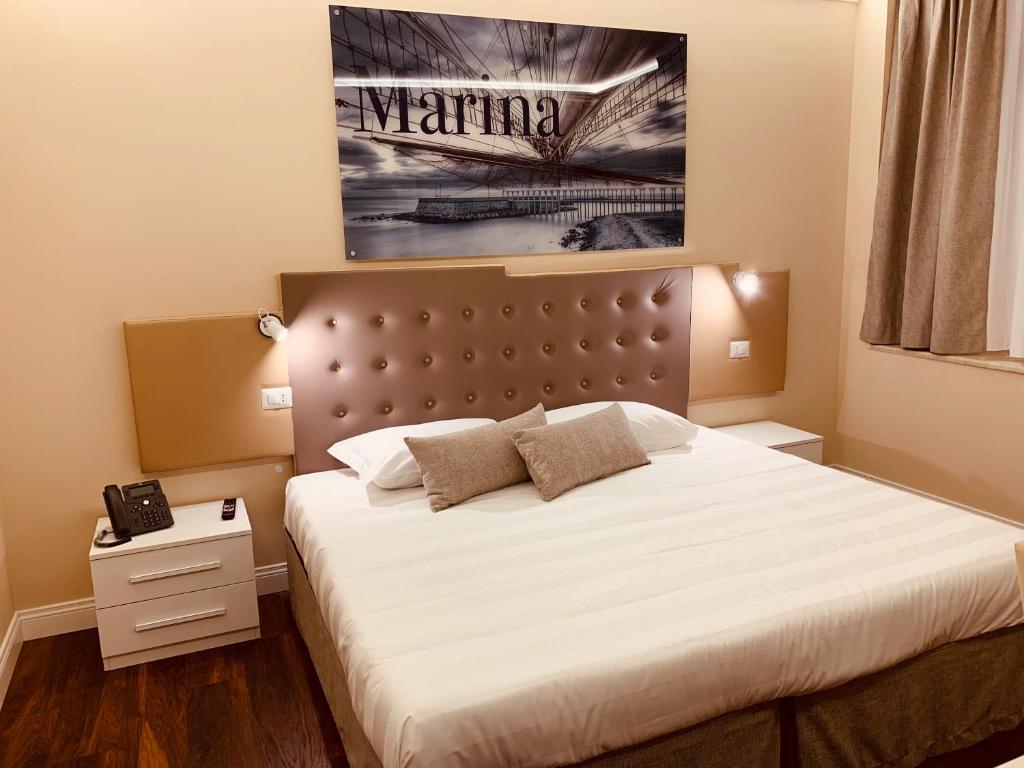 um quarto com uma cama e uma fotografia na parede em 7 Bell's House em Civitavecchia