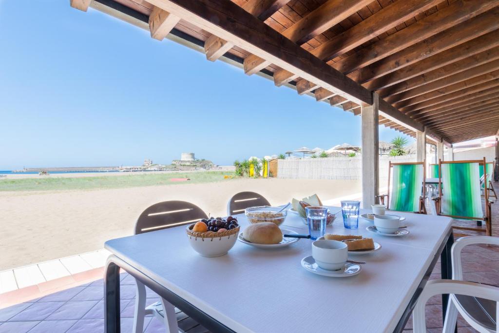 un tavolo blu con una ciotola di cibo sulla spiaggia di Residenza Solemar a Bosa Marina