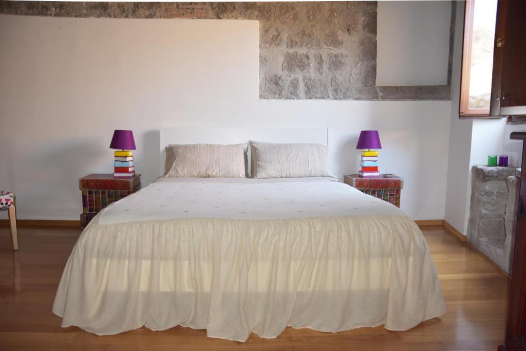 ein Schlafzimmer mit einem weißen Bett mit zwei Lampen in der Unterkunft Al Libro Letto in Viterbo