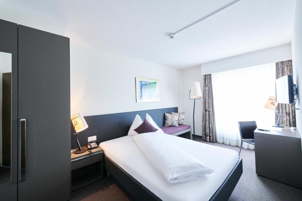Postel nebo postele na pokoji v ubytování Hotel Holiday Thun