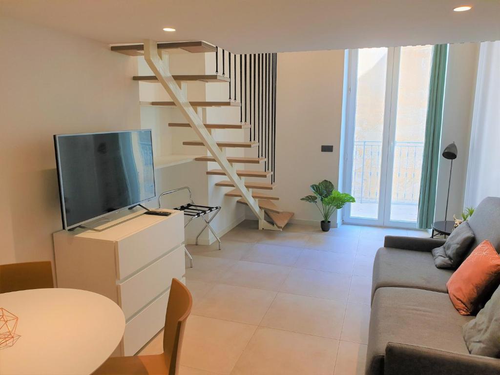 - un salon avec une télévision et un escalier dans l'établissement DUPLEX BALCON CENTRE MER 206, à Nice