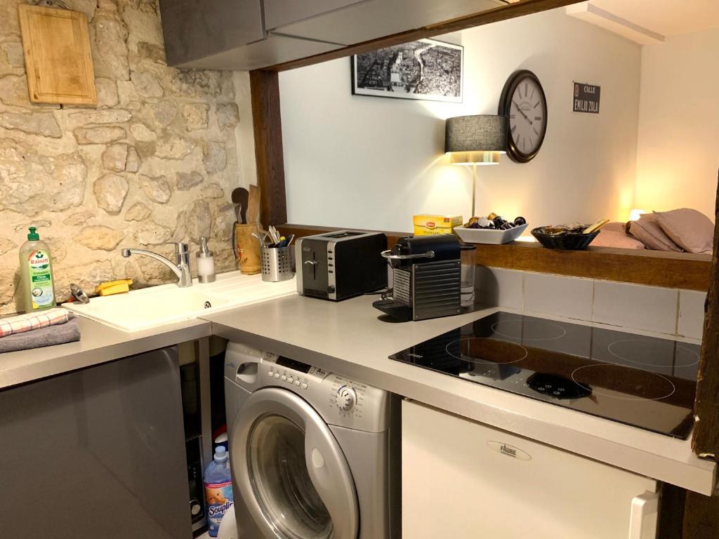 a kitchen with a washing machine and a sink at Lovely studio Le Marais in Paris
