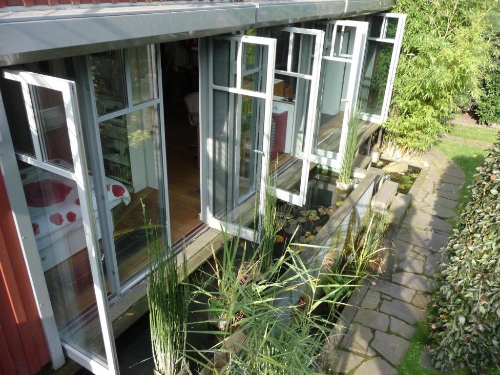 eine Reihe von Fenstern auf ein Haus mit Pflanzen in der Unterkunft Kleine Oase in Bottrop