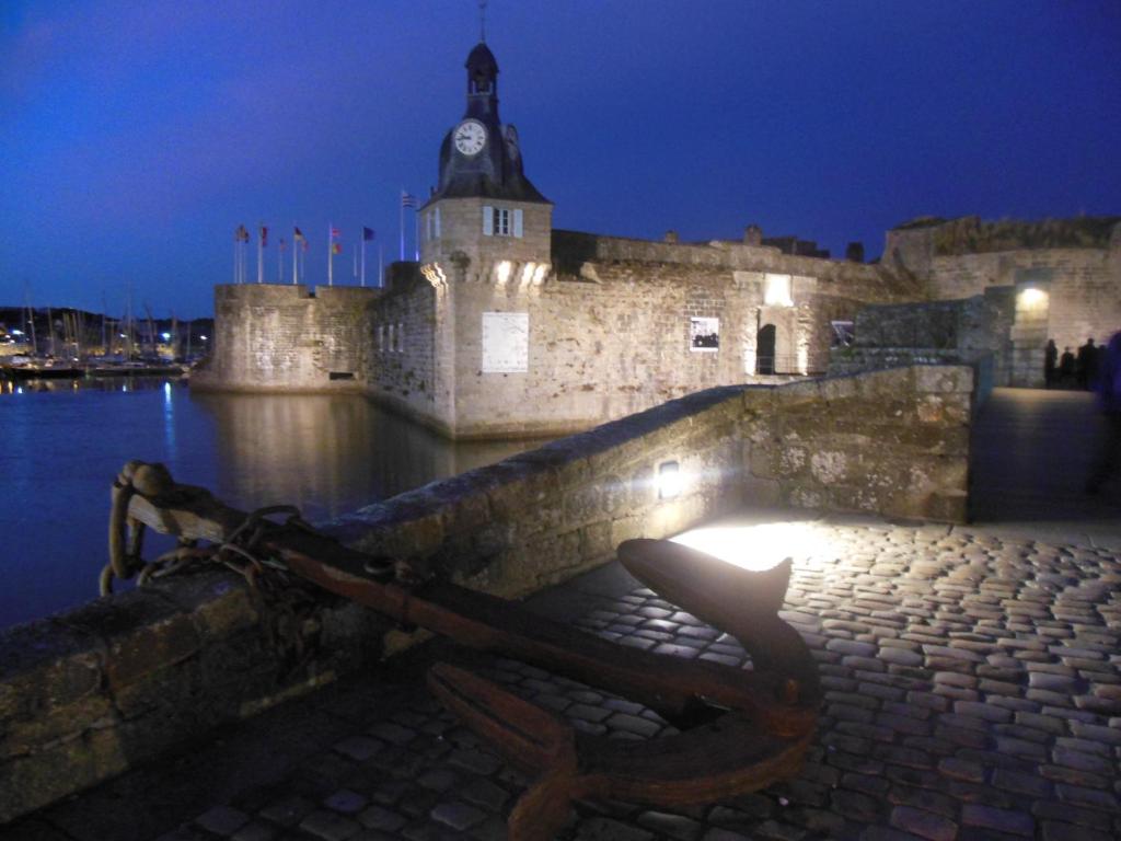 a bench in front of a building with a clock tower at Urban Sunny & Cosy in Concarneau