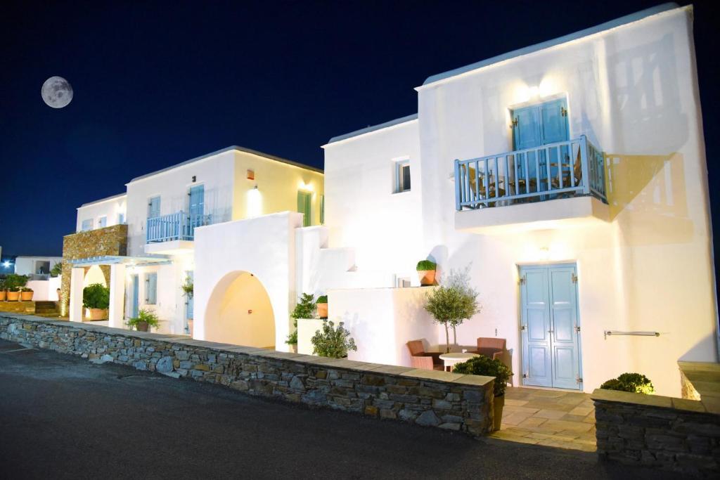 une maison blanche avec une porte bleue la nuit dans l'établissement Hotel Messaria, à Kythnos