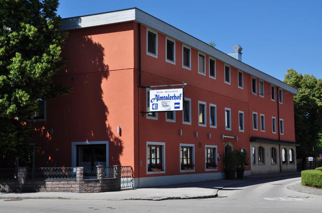 een rood gebouw met een bord aan de zijkant bij Hotel Almtalerhof in Linz