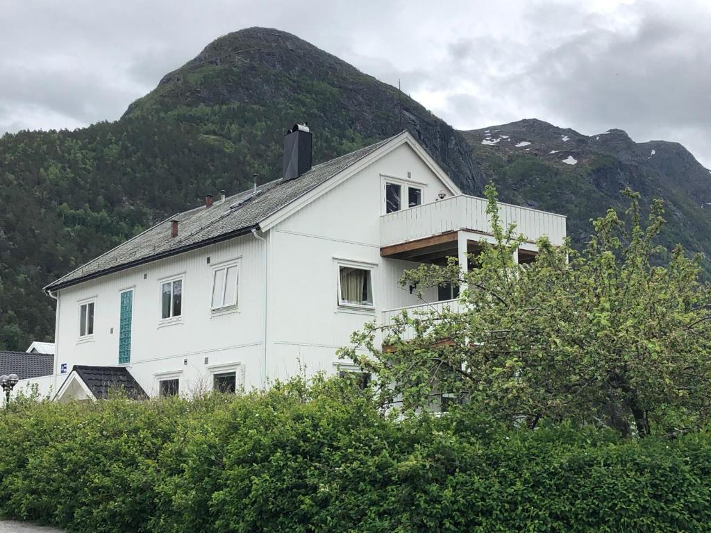 a white house with a mountain in the background at Åndalsnes gustehouse in Åndalsnes