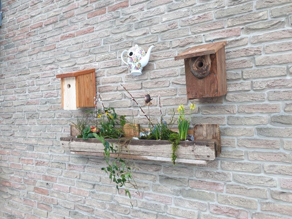 eine Ziegelmauer mit einem Blumenpflanzer drauf in der Unterkunft Ferienwohnung Vogelvilla in Altenbeken