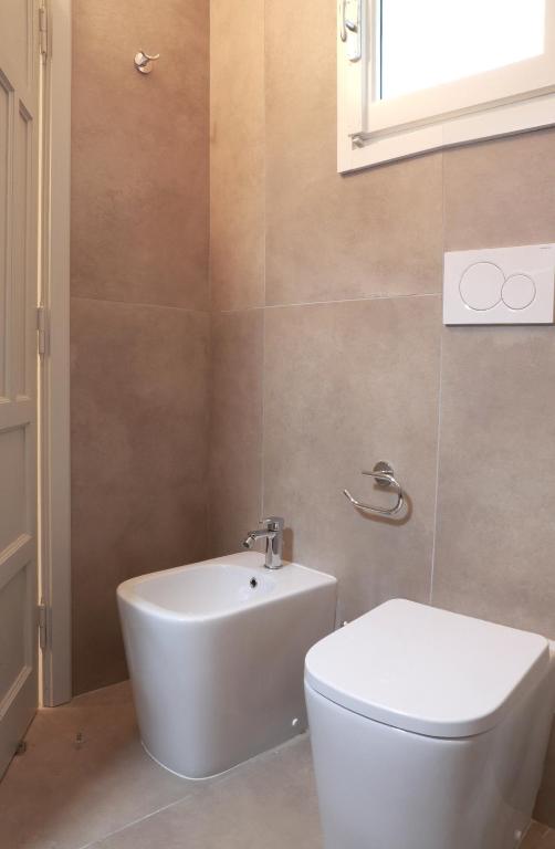 a bathroom with a white toilet and a window at Dimora Villa Serena Porto Selvaggio in Santa Caterina di Nardò