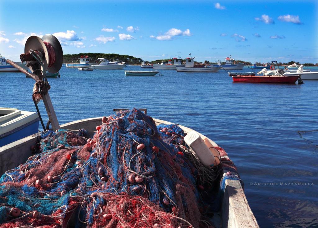 a boat with a pile of rope in the water at Dimora Villa Serena Porto Selvaggio in Santa Caterina di Nardò