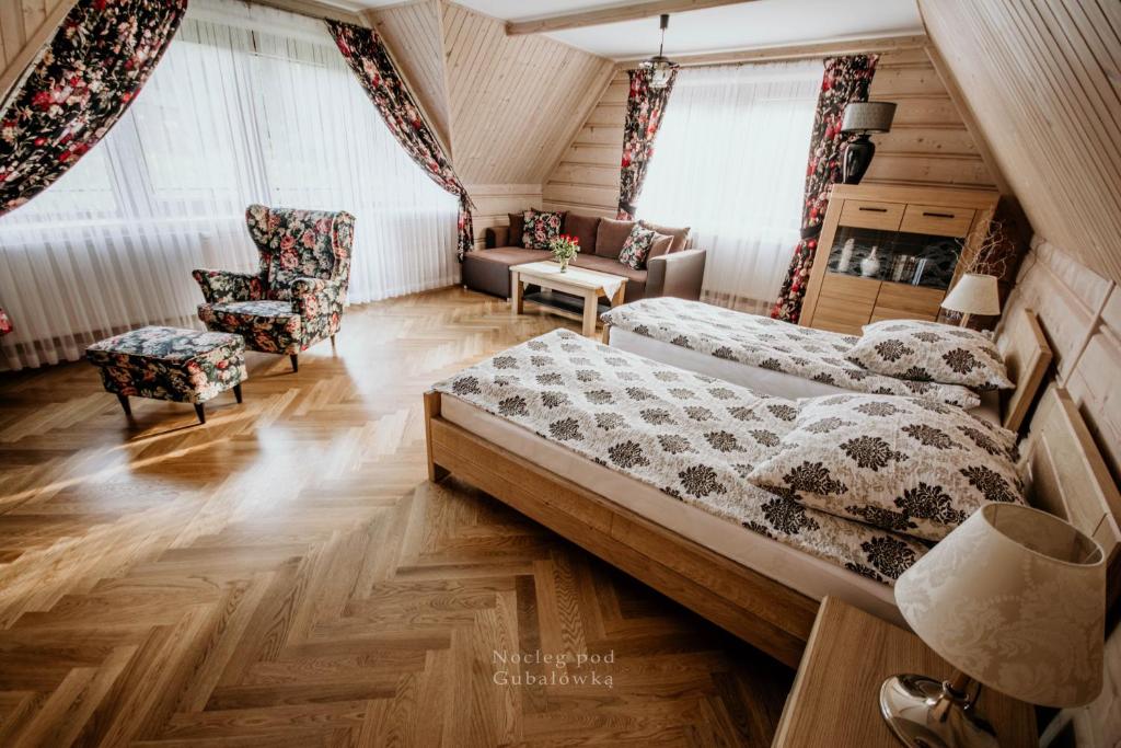 a bedroom with two beds and a couch and a chair at Nocleg Pod Gubałówką in Nowe Bystre