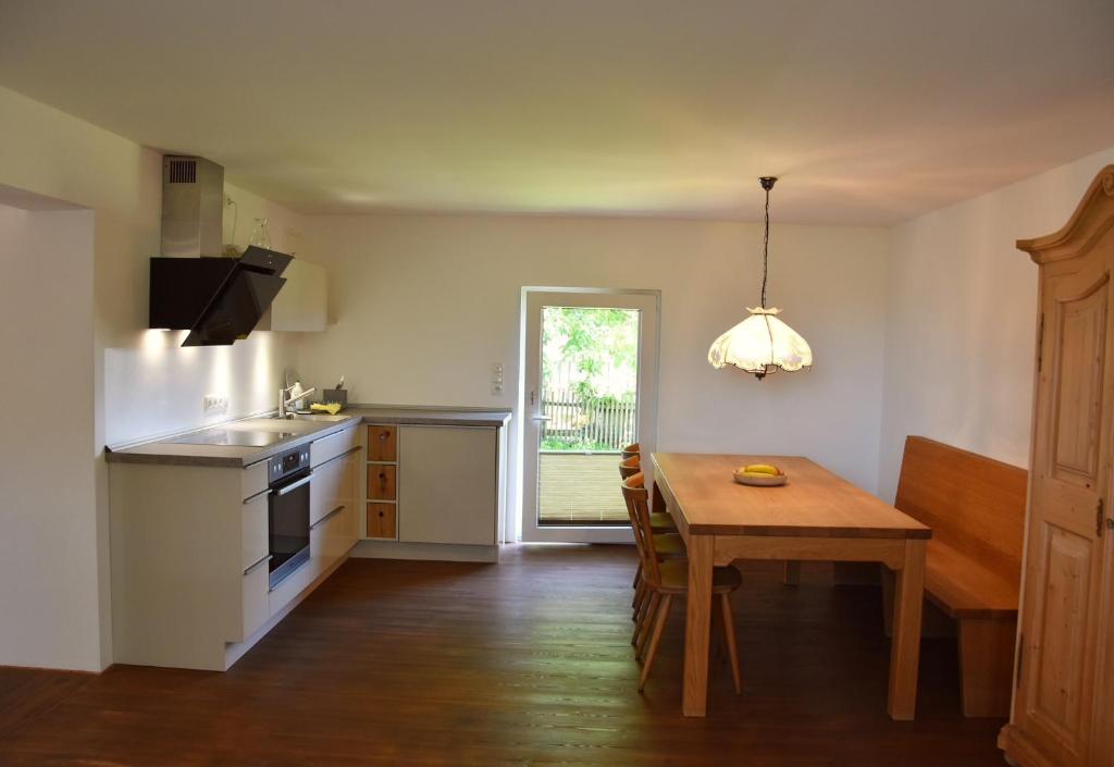a kitchen with a wooden table and a dining room at Gästehaus Palli in Unterdietfurt