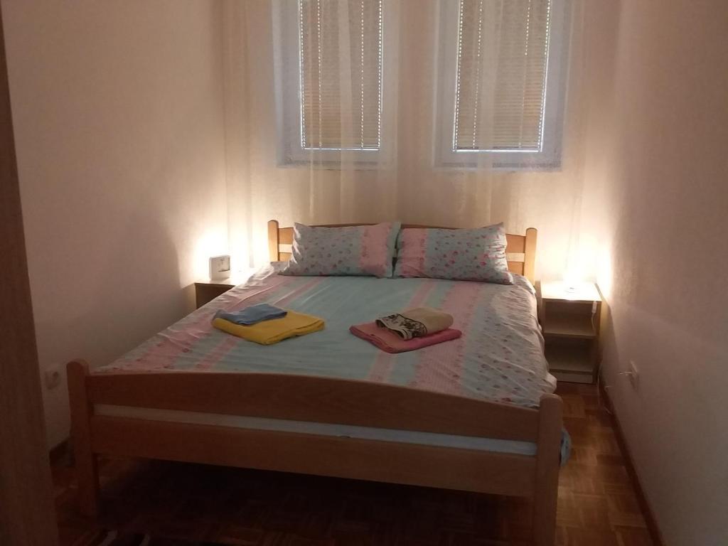 a bedroom with a bed with two towels on it at Apartman Jevtić 1 in Gornja Toplica