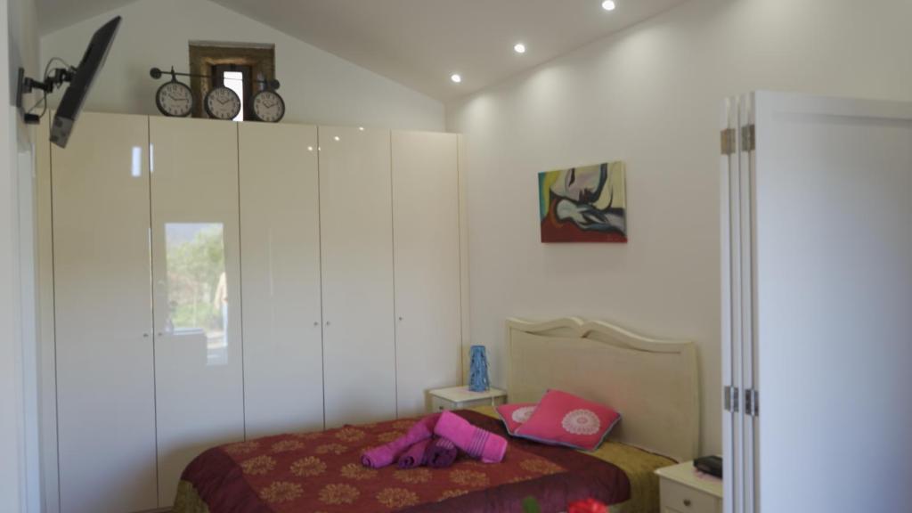 ein Schlafzimmer mit einem Bett mit rosa Schuhen darauf in der Unterkunft Casa da Eira in Arouca