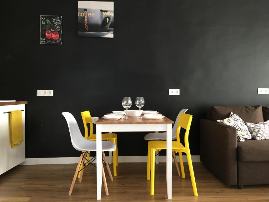 ein Esszimmer mit einem Tisch und gelben Stühlen in der Unterkunft Ladrillo, apartment by the sea, Santa Pola in Santa Pola