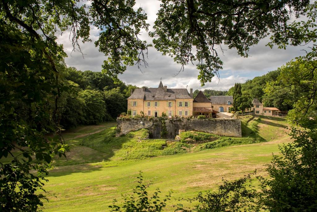 un vieux château sur une colline avec un champ verdoyant dans l'établissement Château de Valette, à La Bachellerie