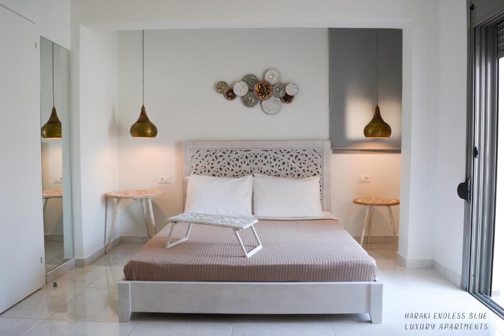 a bedroom with a bed and two tables at Haraki Endless Blue Luxury Apartments in Haraki