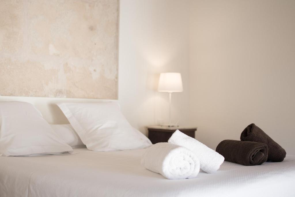 a white bed with white pillows and a lamp at Orient Capdepera - Turismo de Interior in Capdepera