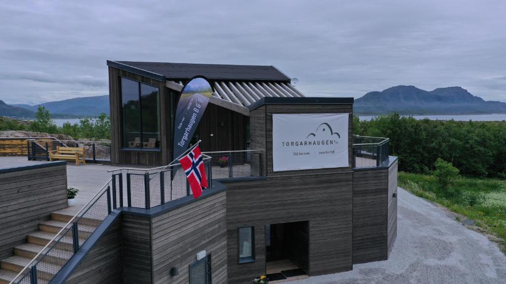 a large building with a flag on top of it at Torgarhaugen Gjestehus in Brønnøysund
