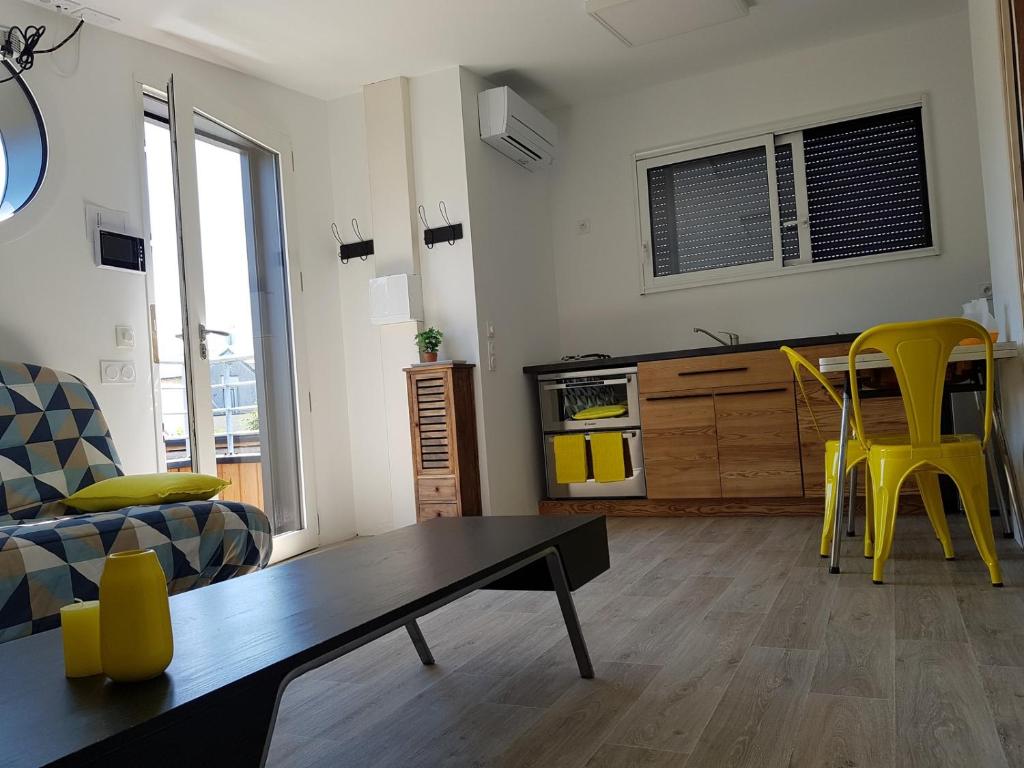 un soggiorno con tavolo e sedie gialle di Angers Green Lodge - Yellow Sun Appartement ad Angers