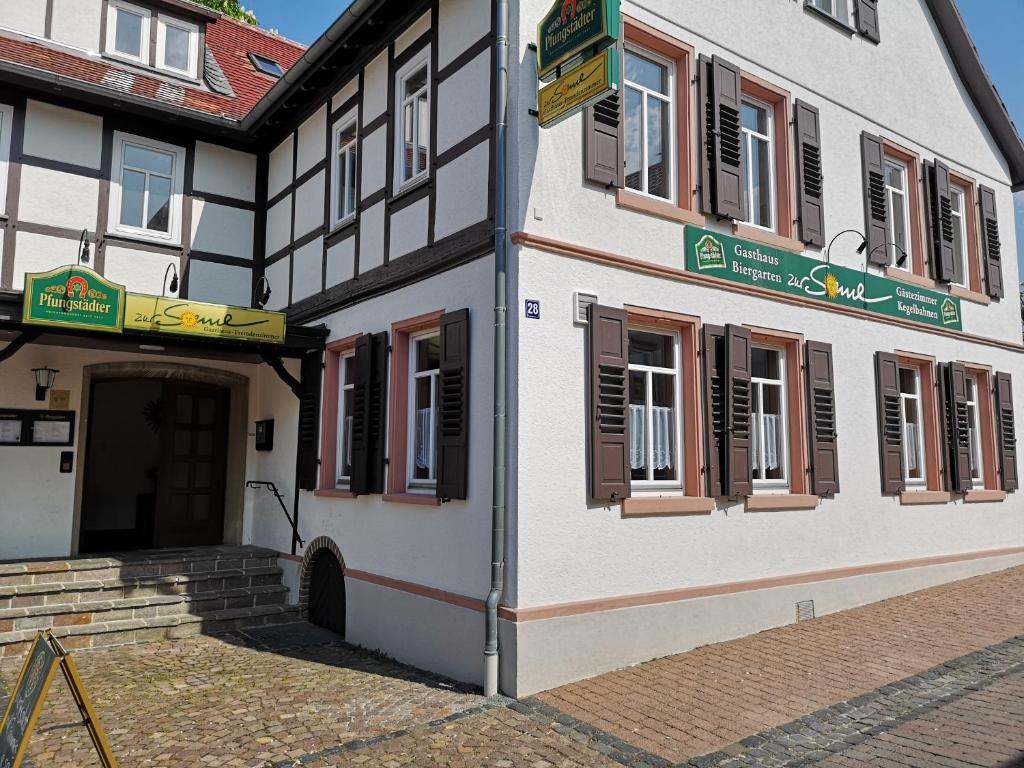 un bâtiment blanc et noir avec une porte dans l'établissement Zur Sonne, à Alsbach-Hähnlein