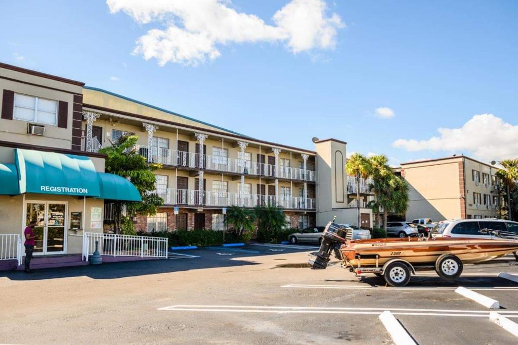 a car parked in a parking lot in front of a hotel at Executive Economy Lodge in Pompano Beach