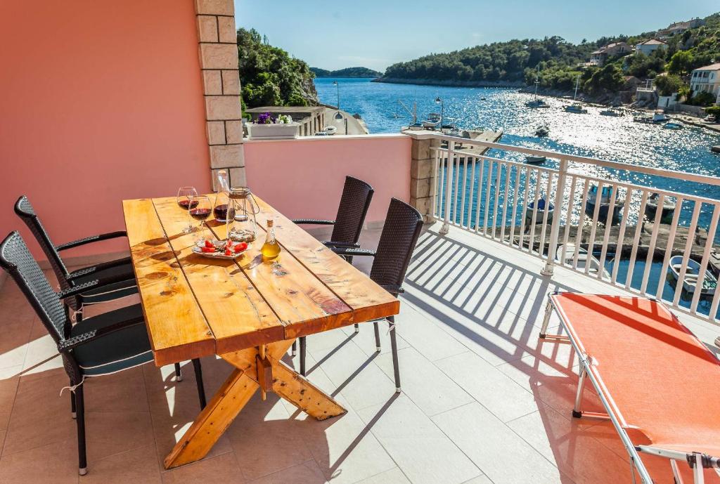 una mesa de madera en un balcón con vistas al agua en Apartment Jakov Grscica, en Prizba