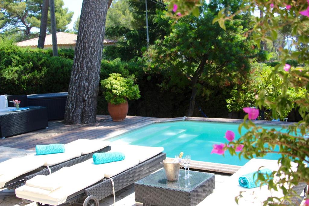 een zwembad met 2 ligstoelen en een tafel bij Côte d'Azur Villa - Juan-les-Pins - 900m beach in Antibes