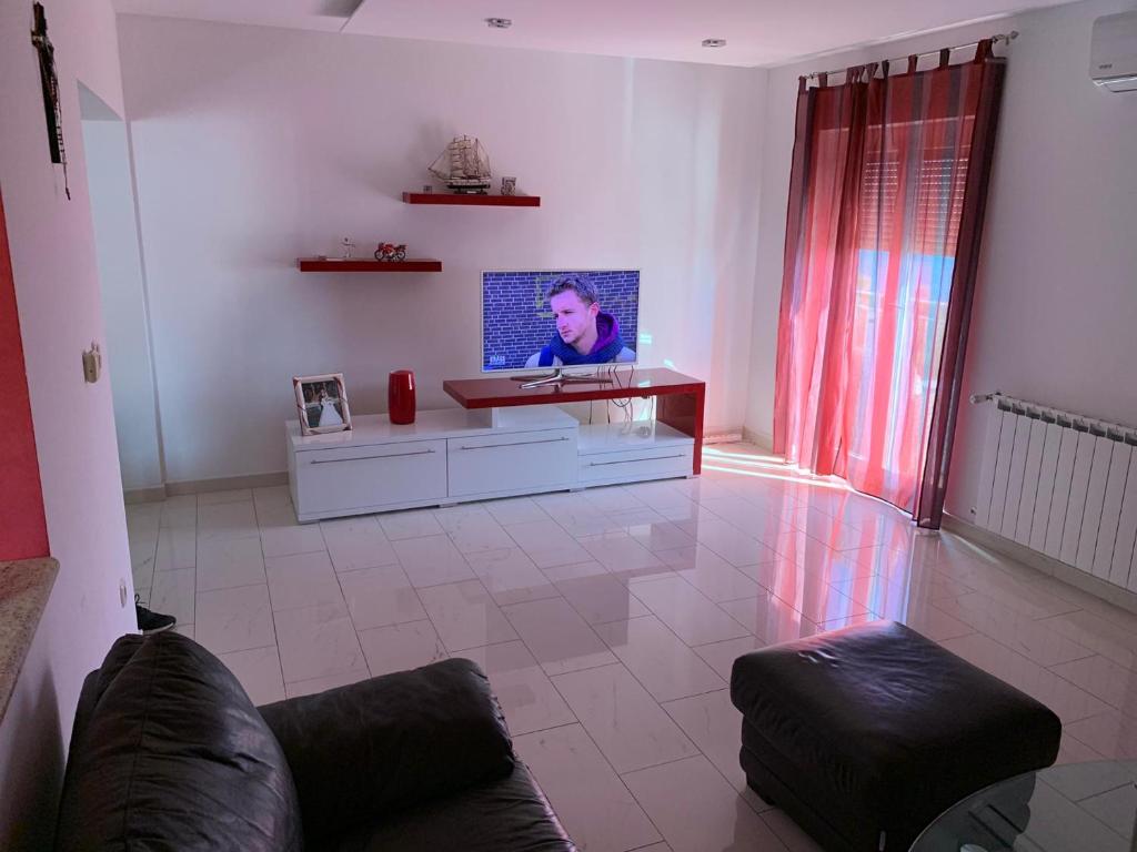 uma sala de estar com uma televisão e um sofá em Villa Mirjana em Dramalj