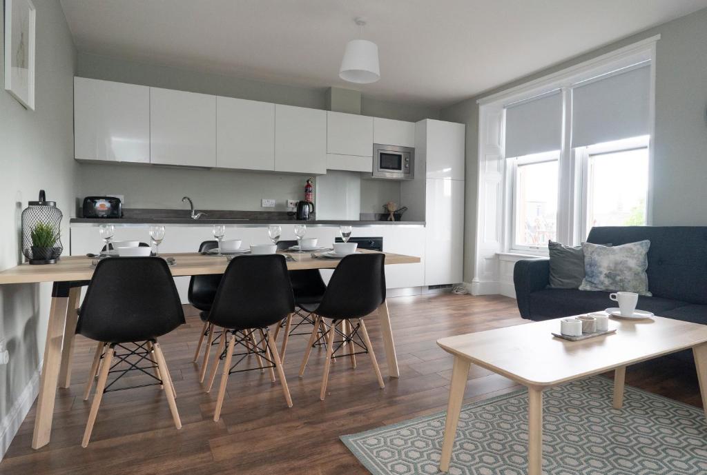 uma cozinha e sala de estar com mesa e cadeiras em GreenStar Apartments em Dundee