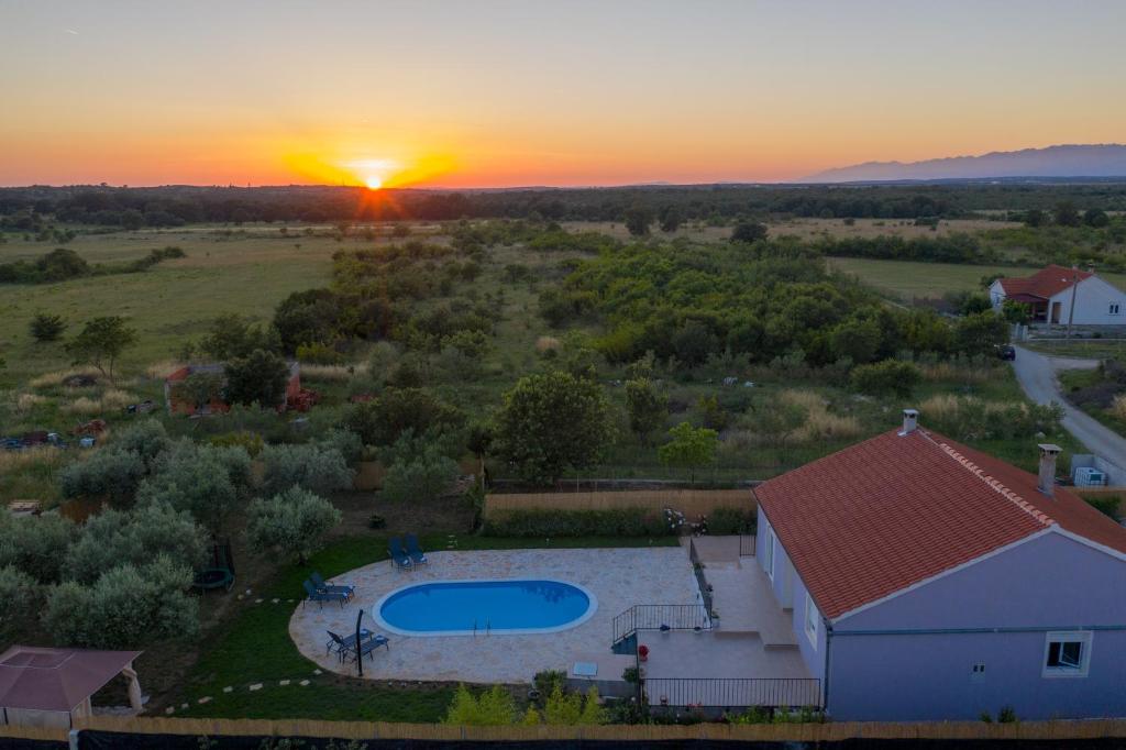 eine Aussicht über ein Haus mit Pool und Sonnenuntergang in der Unterkunft Holiday house Roko in Gornji Zemunik