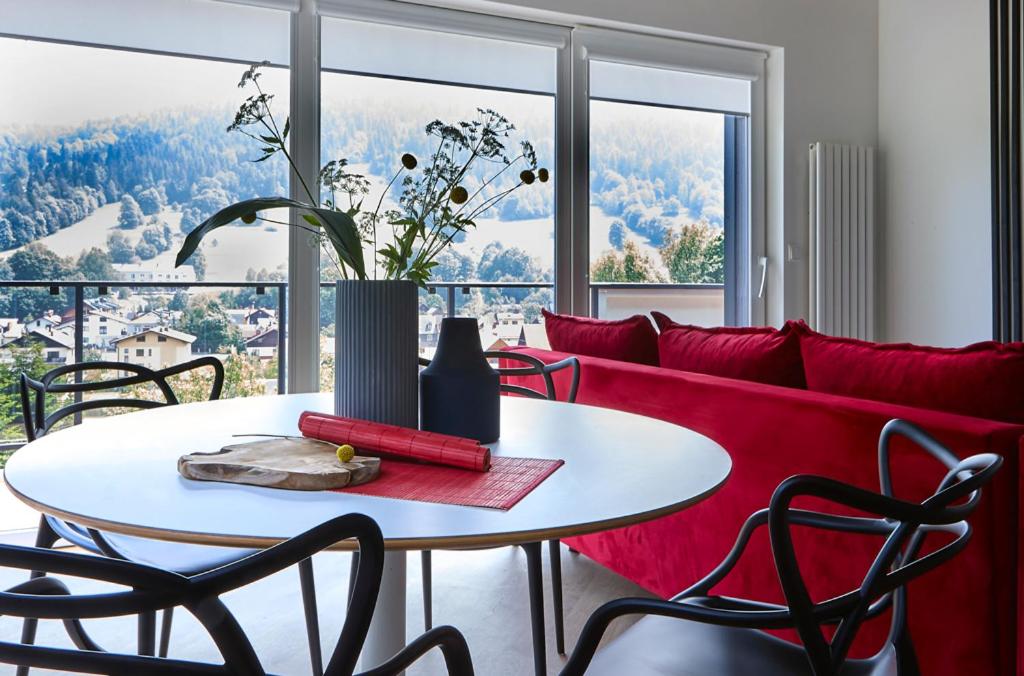 uma sala de estar com um sofá vermelho e uma mesa em Apartament Berg em Szczyrk