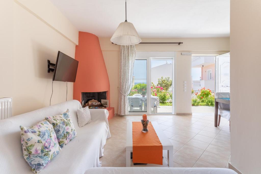 a living room with a white couch and a fireplace at Markella's House in Vravrona