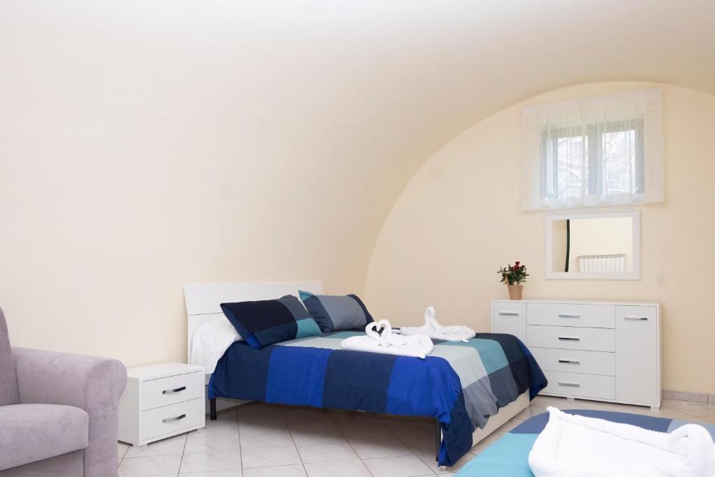 ein Schlafzimmer mit einem Bett und einem Stuhl in der Unterkunft B&B CASA VACANZA Cioffi in Vico Equense