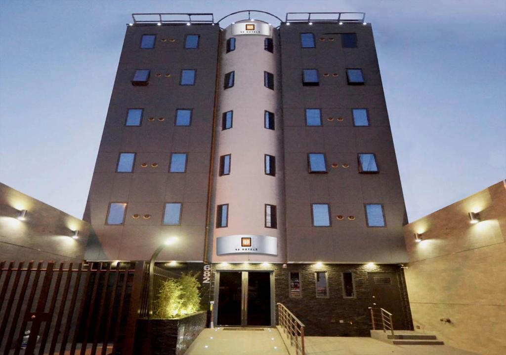 un grand bâtiment blanc avec un escalier devant lui dans l'établissement qp Hotels Trujillo, à Trujillo