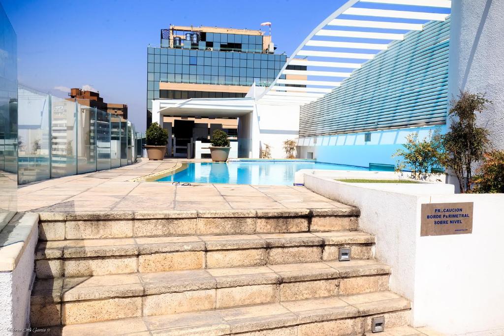 a stairway leading up to a building with a swimming pool at Apart hotel Fraga in Santiago