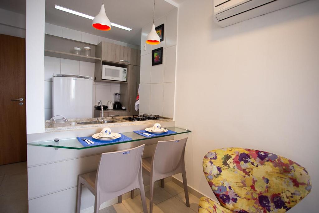 a kitchen with a counter and chairs in a room at Flat Boa Viagem in Recife