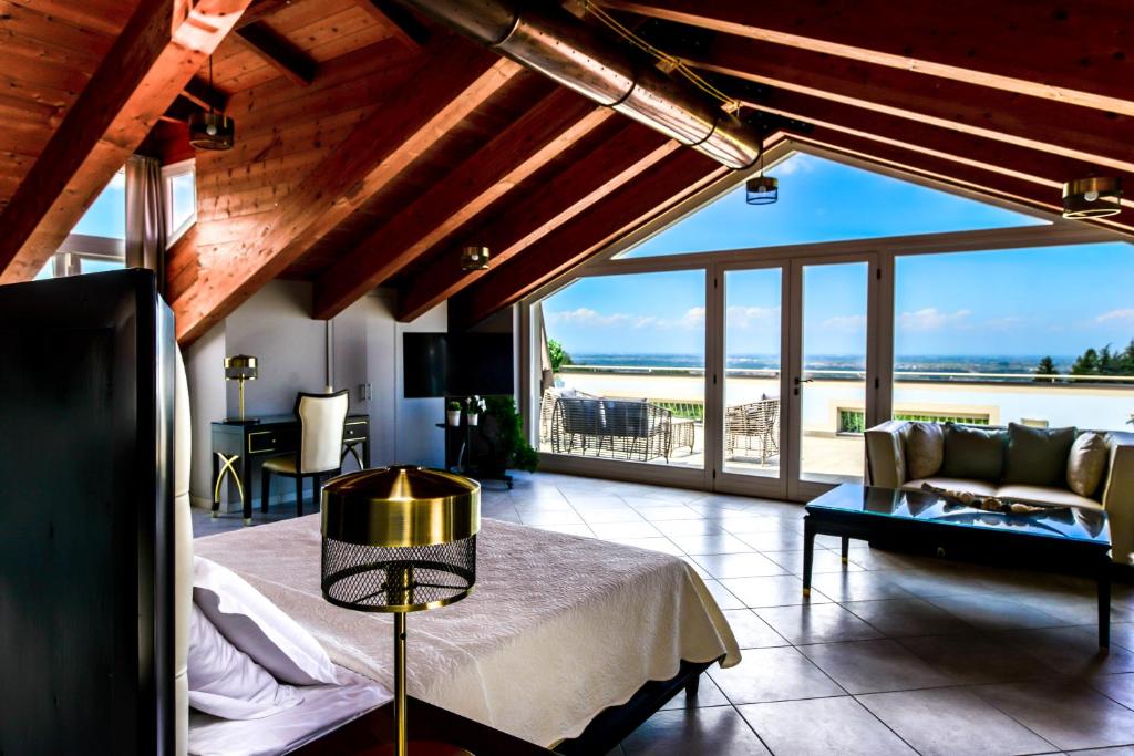 a bedroom with a bed and a living room with a view at Altezza in La Morra