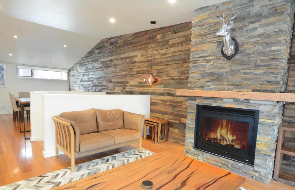 a living room with a fireplace and a chair at Apartment K2 06 in Mount Buller