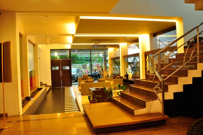 a living room with a staircase in a house at Sayoojyam Residency in Palakkad