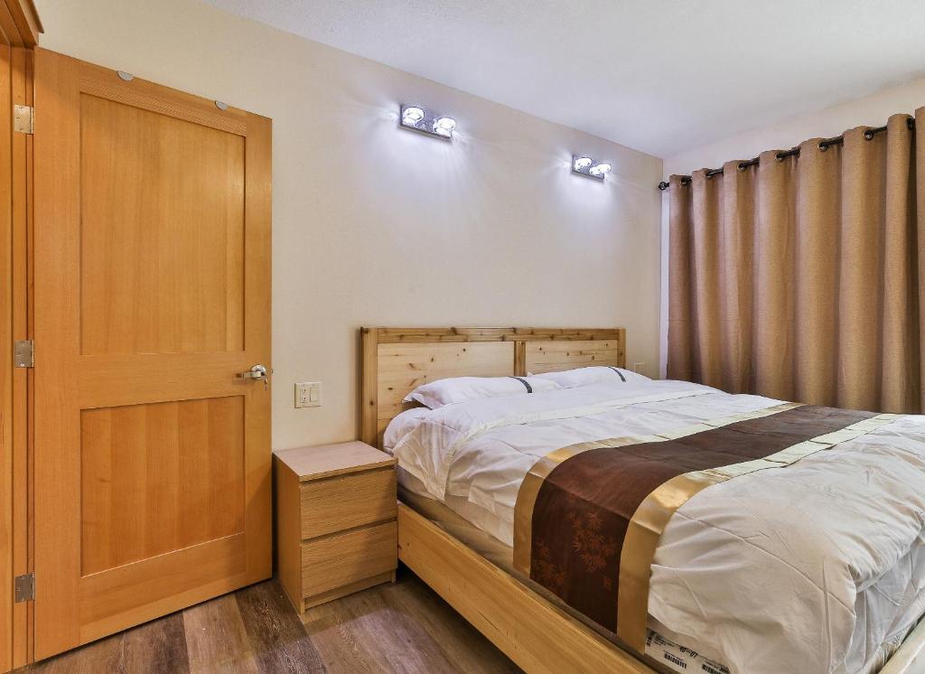 um quarto com uma cama e uma porta de madeira em Riverfront Estate Bed&Breakfast Banff em Banff