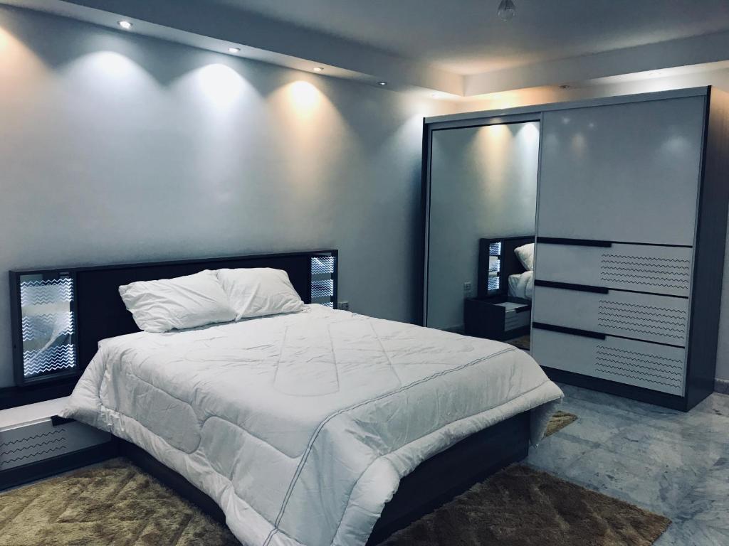 Un dormitorio con una cama grande y un espejo. en Shehab Saraya, en El Cairo