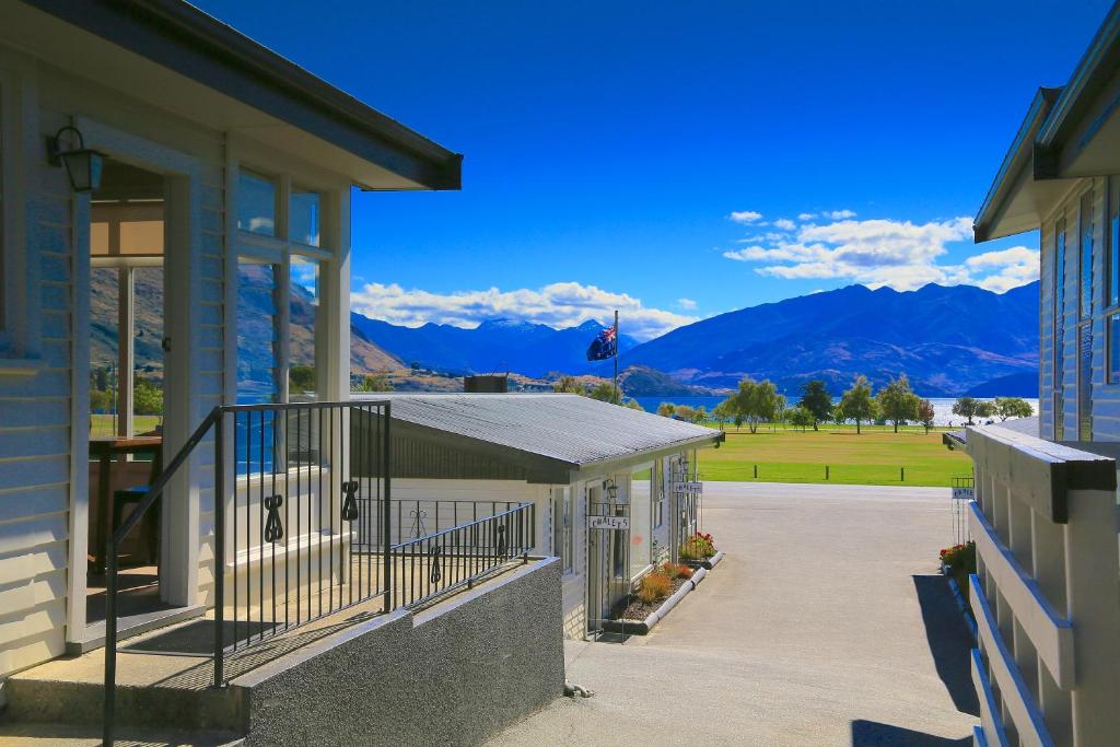 a building with a balcony with mountains in the background at Wanaka View Motel in Wanaka