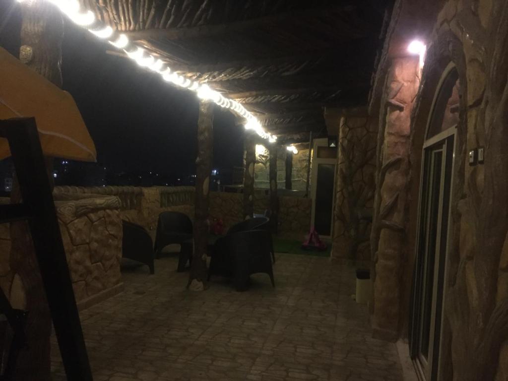 a patio at night with lights on a stone wall at Al-Madina Tower Apartments in Marsa Matruh