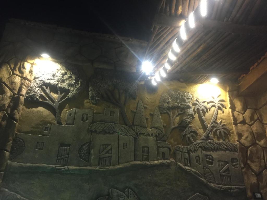 a mural on a wall in a building with lights at Al-Madina Tower Apartments in Marsa Matruh