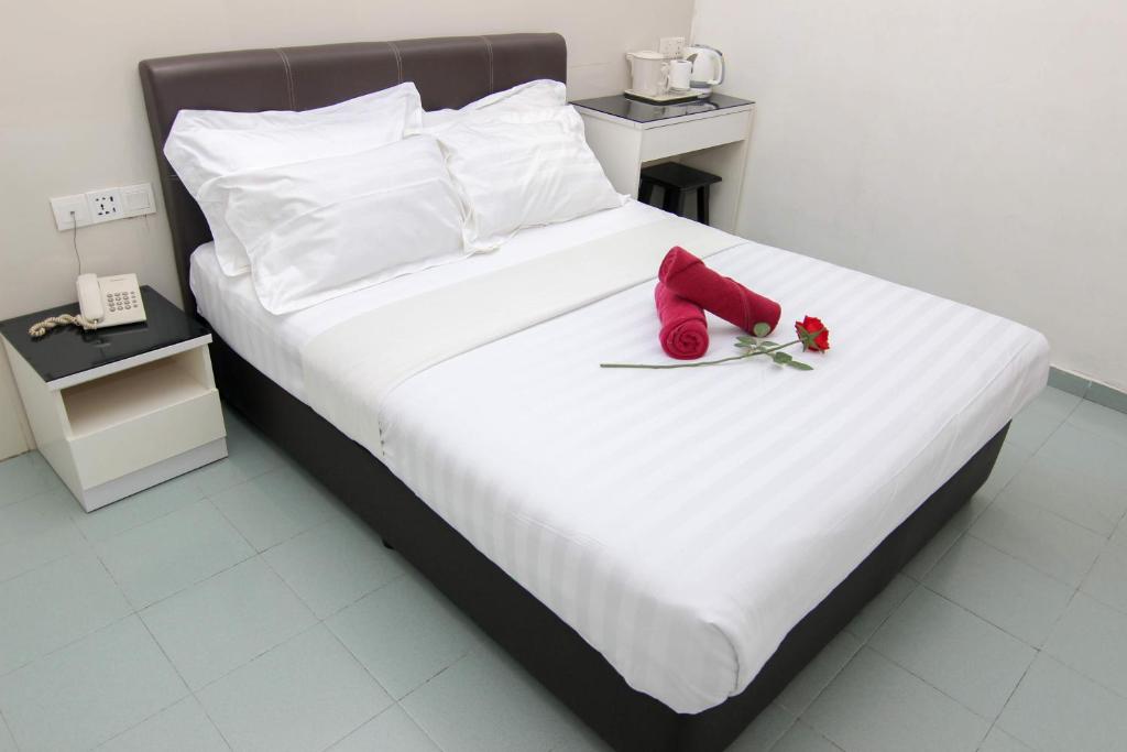 a bed with red shoes and roses on it at Rose Cottage Hotel Taman Johor Jaya in Johor Bahru